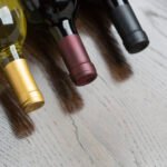 various wine bottles on a reflective wood surface abstract.